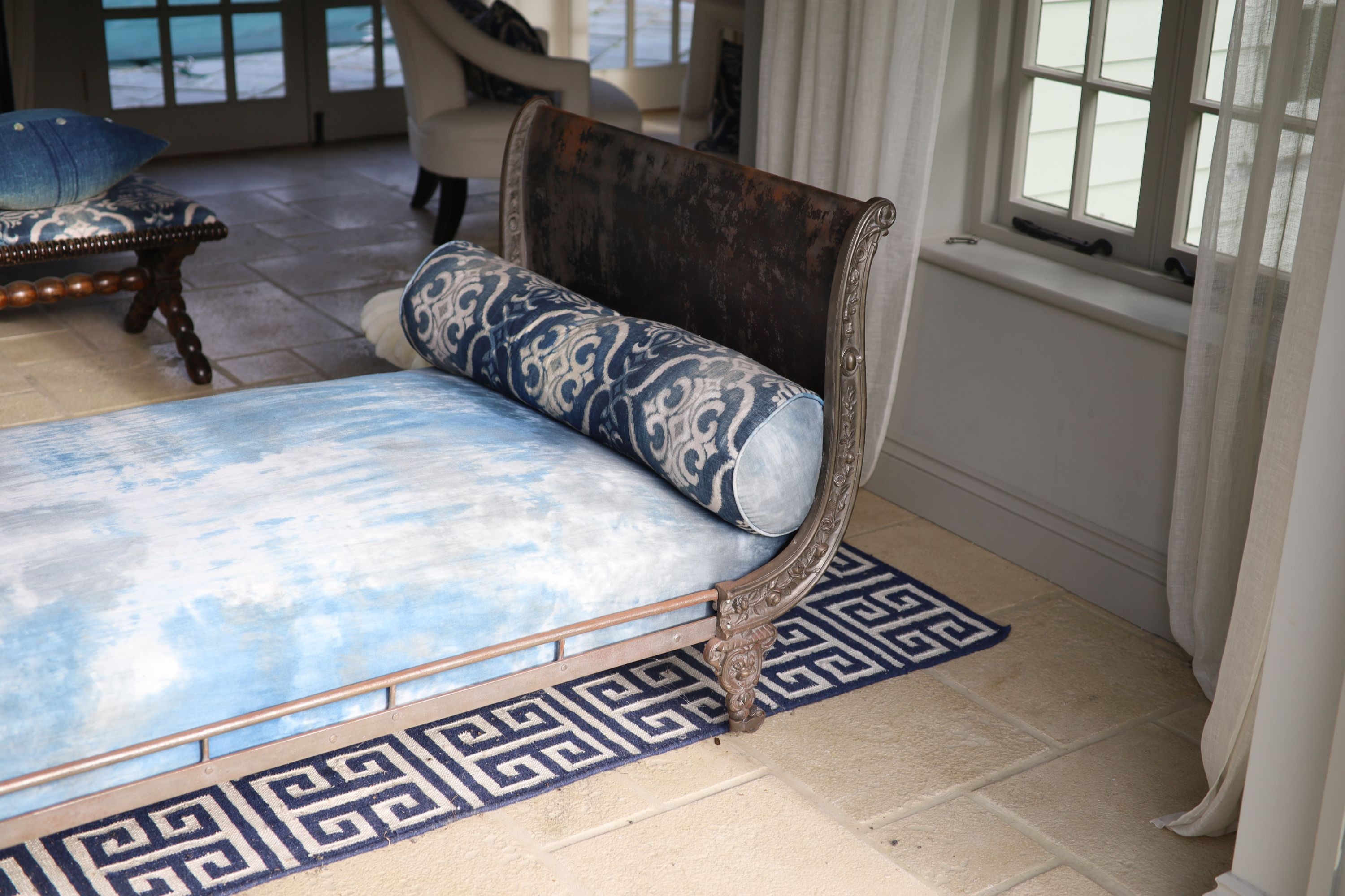 A late 19th century French cast metal day bed, with blue fabric upholstery and two bolsters, width 194cm depth 100cm height 84cm